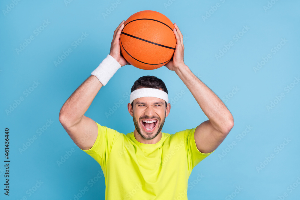 Portrait of attractive cheerful guy throwing ball having fun weekend rest isolated over bright blue color background