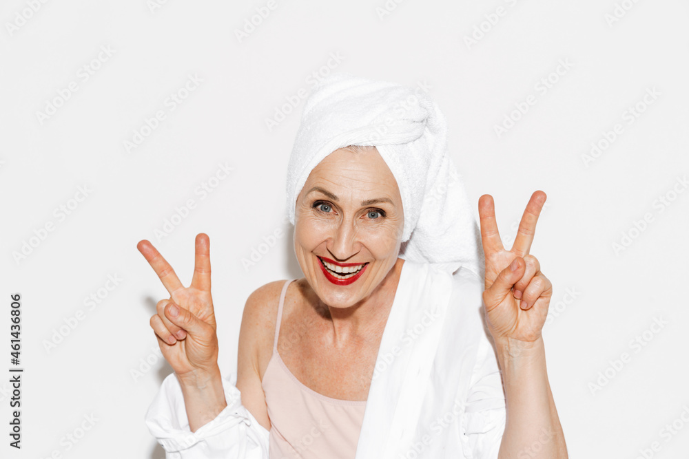 Senior woman wearing towel smiling while gesturing peace sign Senior woman wearing towel smiling while gesturing peace sign