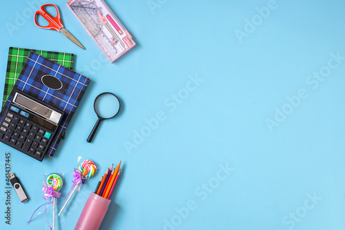 Creative flat lay school supplies on blue background for back to school concept