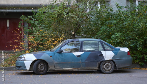 An old multicolored car at the entrance to a residential building, Iskrovsky Prospekt, St. Petersburg, Russia, October 2021