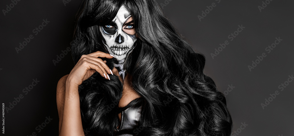 Beautiful model in Halloween makeup on black background. Sexy woman in top hat and skull makeup. Halloween makeup concept. Beautiful model in Halloween makeup on black background. Sexy woman in top hat and skull makeup. Halloween makeup concept.