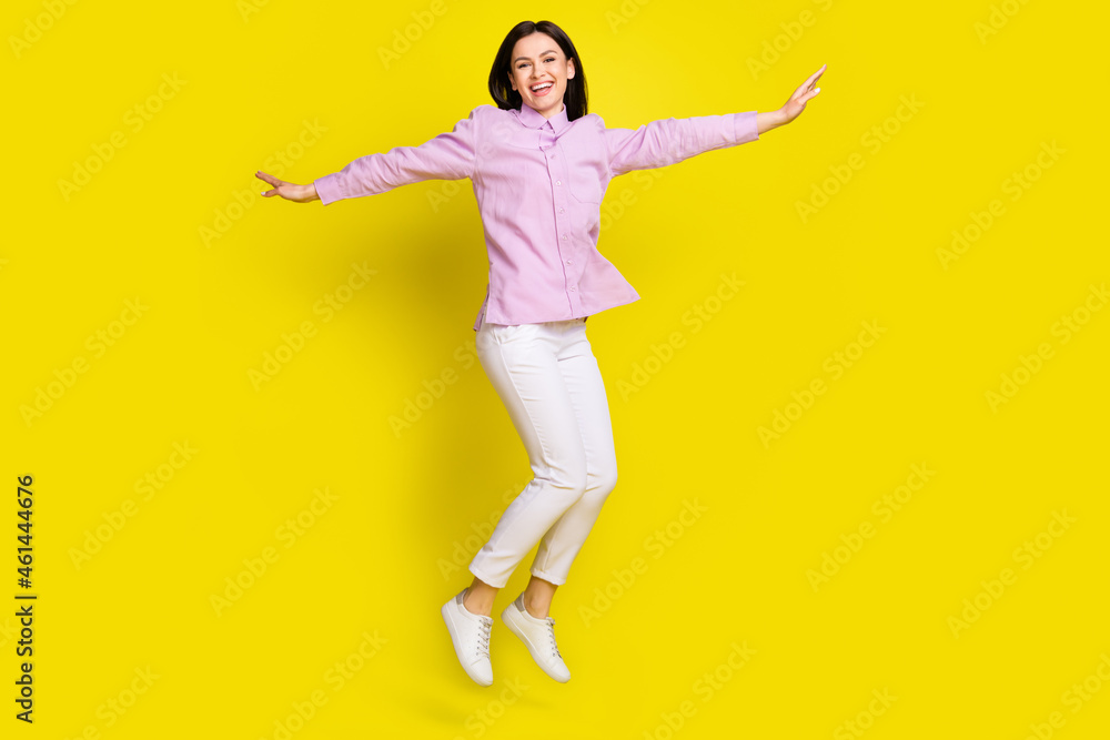 Full length body size view of attractive funny cheery girl jumping having fun free isolated over bright yellow color background