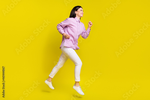 Full size profile photo of nice brown hairdo young lady run wear pink shirt pants isolated on yellow color background © deagreez