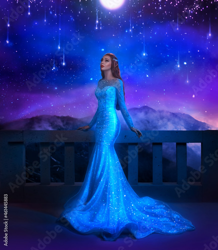 Fantasy woman princess stands on balcony looks at night sky space cosmos stars. Girl enjoy magic starfall ball. Elegant long shiny blue dress. Character cosplay book ACOTAR Fairy Queen Feyre Archeron photo