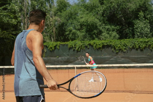 Couple playing tennis on court during sunny day © New Africa