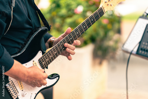 Close up view of a musician playing a electric guitar in a live concert outdoors