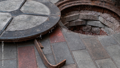 Blocked sewer drain. The water of recycling. Uninstalling septic tank with old iron manhole.