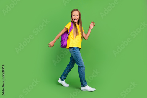 Full length body size view of attractive cheerful amazed girl going visit secondary school isolated over vivid green color background