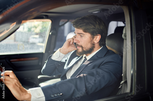 emotional man in a suit in a car a trip to work communication by phone © SHOTPRIME STUDIO