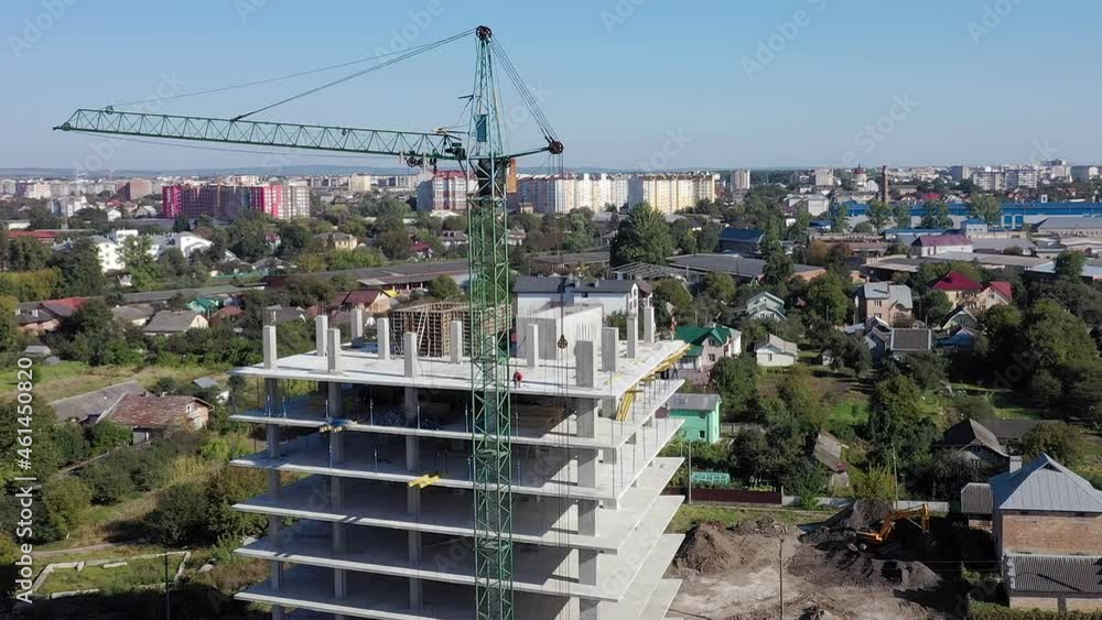 Workers work with crane and steel concrete reinforcement at large construction site of modern building. Modern monolithic industrial construction. Workers work with crane and steel concrete reinforcement at large construction site of modern building. Modern monolithic industrial construction.