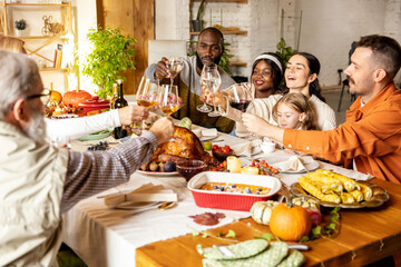 Happy Thanksgiving dinner party with family and friends with turkey and holiday traditional food, dishes on table.