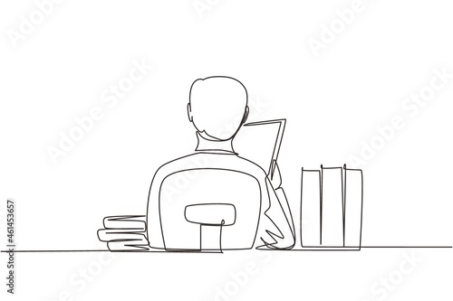Continuous one line drawing back view of young man sitting at desk and reading book, student studying hard and preparing before exam with pile of books. Single line draw design vector illustration