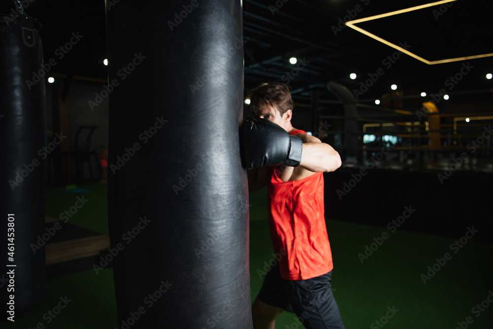 boxer working out with punching bag in sports center.
