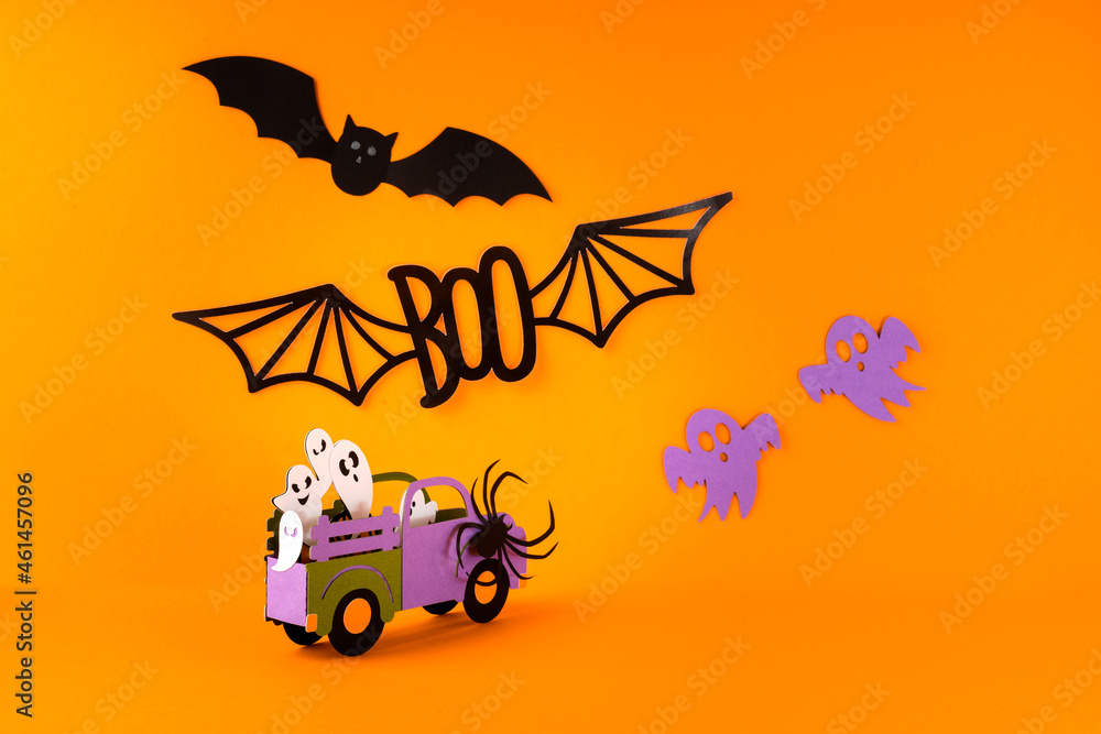 Naklejka premium Happy halloween holiday concept. Halloween handmade paper decorations, spiders, ghosts in car, bats, boo text on orange background. Halloween festival party, greeting card mockup with copy space.