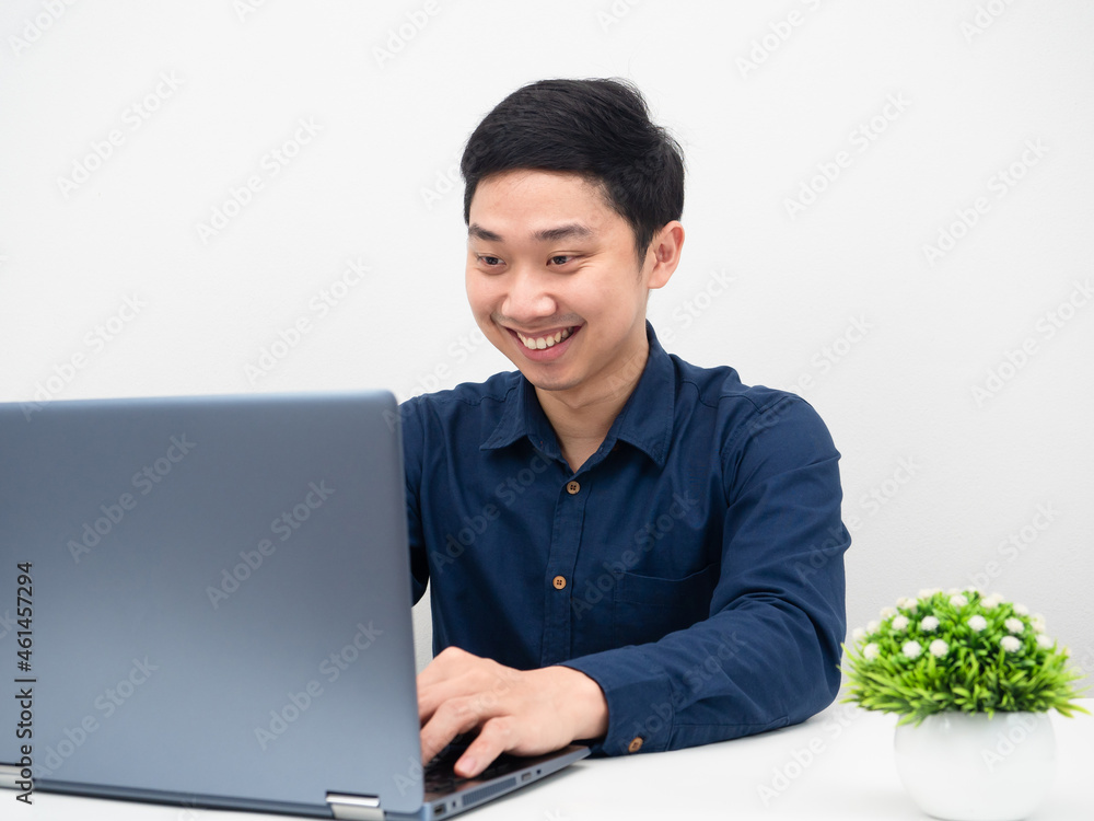 Man working with his laptop feeling happy and smile at the table work from home concept Man working with his laptop feeling happy and smile at the table work from home concept
