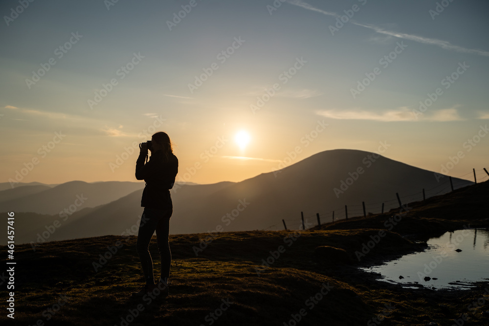 Junge Frau fotografiert nach Wanderung bei Sonnenaufgang am Berg in Salzburg Österreich