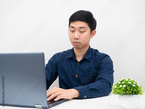 Businessman using laptopn on the table for working online and feeling tried want to sleep photo