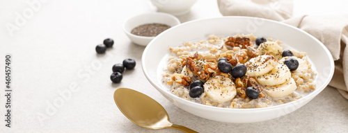 Oatmeal bowl. Oat porridge with banana, blueberry, walnut, chia seeds and almond milk for healthy breakfast or lunch. Healthy food, diet. Banner.