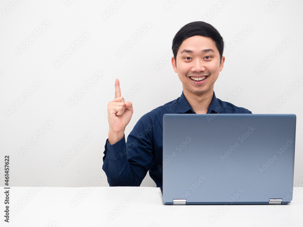 Handsome man with laptop on the table happy smile get idea point finger up at copy space white isolated Handsome man with laptop on the table happy smile get idea point finger up at copy space white isolated