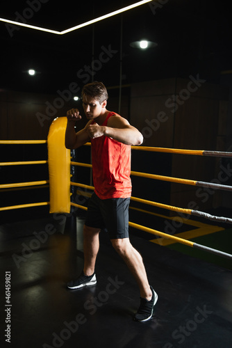 full length view of sportsman boxing in ring while training in gym.