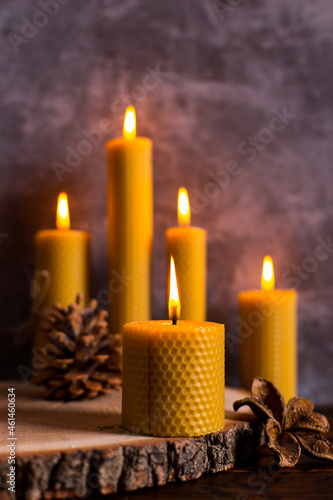 A handmade of natural wax with texture of honeycomb bees candles burns on the table, an unusual element of the interior.