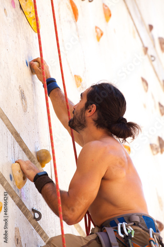 young man climbing in climbing wall, urban sport, summer, self improvement.