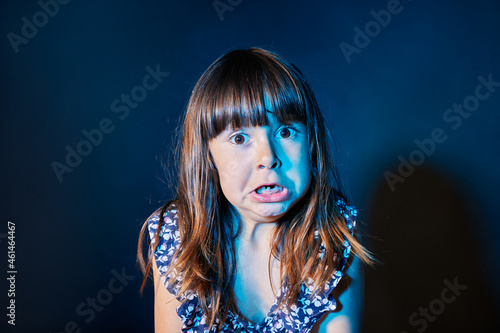 portrait of a frightened girl in a dark environment with colored lights