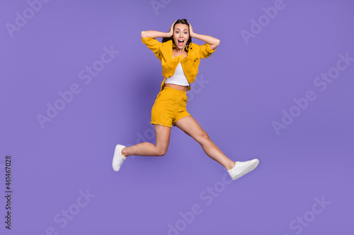 Full length photo of crazy young lady run wear yellow suit sneakers isolated on violet background