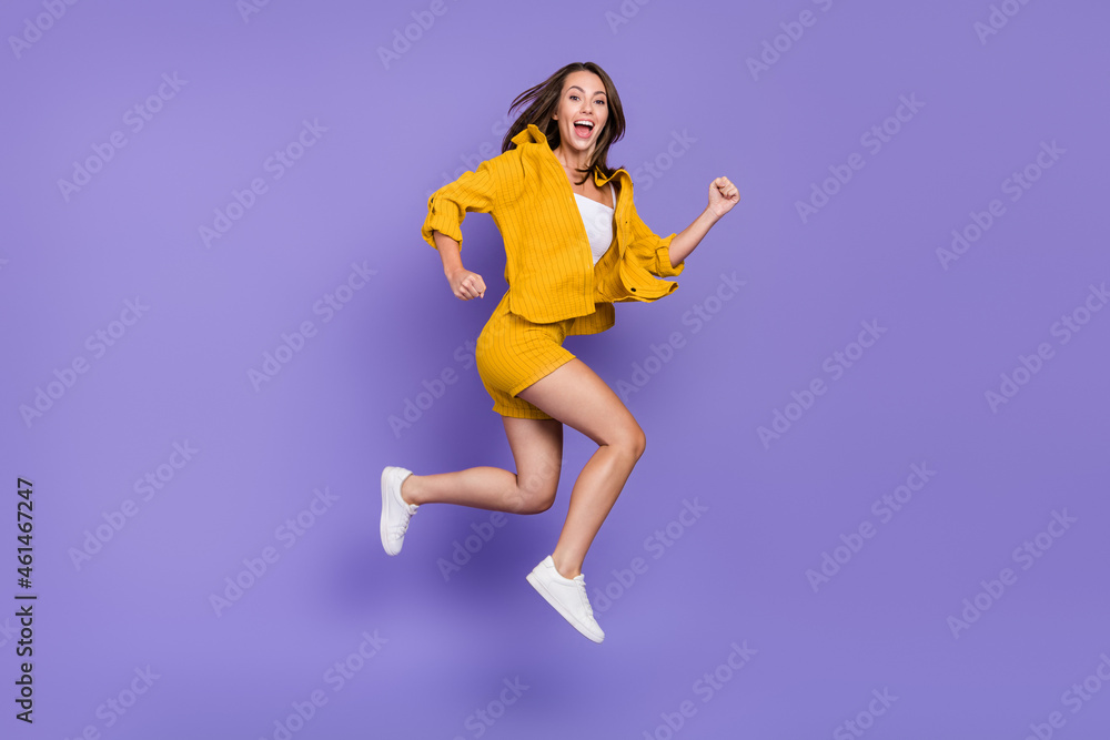 Full length photo of funny millennial lady run wear yellow suit sneakers isolated on violet background