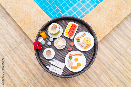 Floating breakfast tray served in morning at poolside in tropical resort
