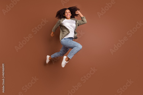 Full size photo of hooray millennial brunette lady jump wear shirt jeans shoes isolated on brown background