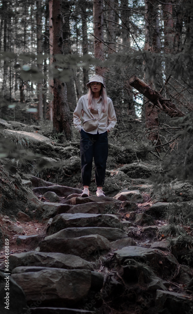 A girl standing in the woods.