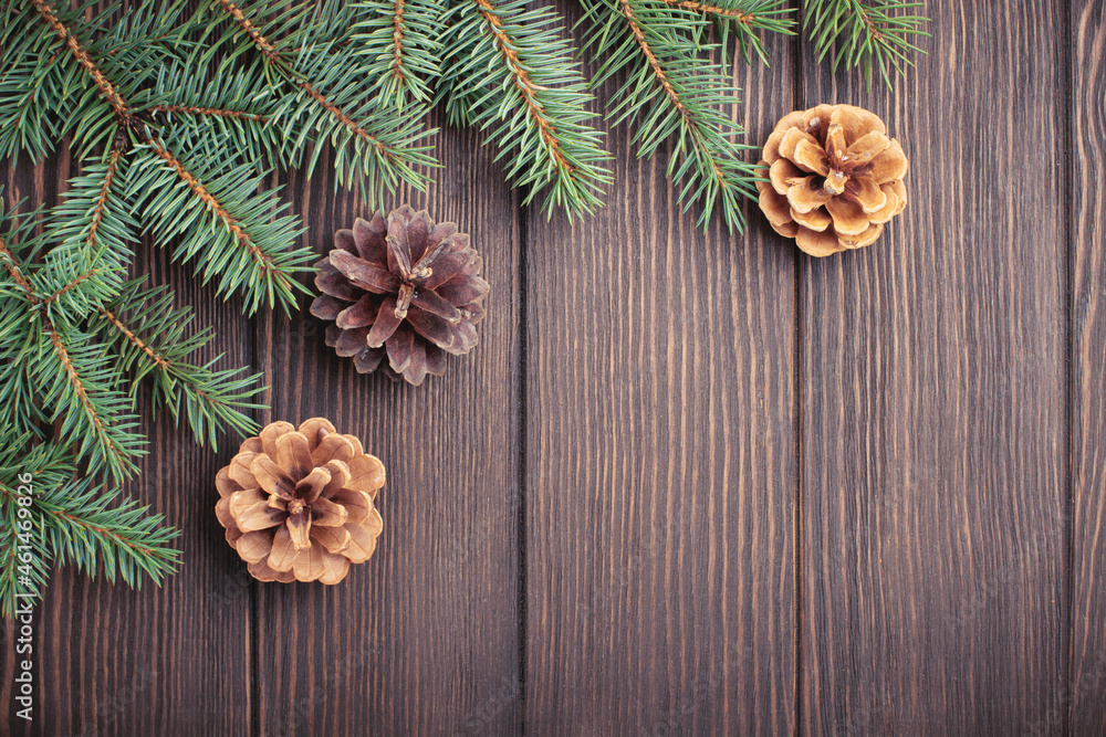 Christmas or New Year background. Fir-tree branches , Christmas tree toys, stars, snowflake and cones on dark brown wooden background. Selective focus. Top view. Copy space Christmas or New Year background. Fir-tree branches , Christmas tree toys, stars, snowflake and cones on dark brown wooden background. Selective focus. Top view. Copy space