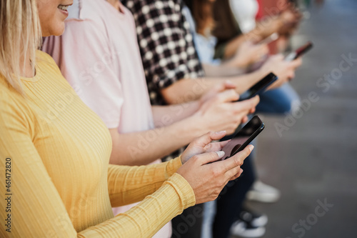 Young happy people using mobile phones outdoor - Focus on left girl