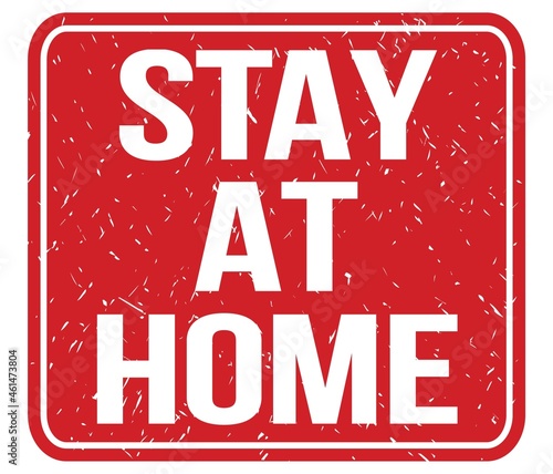 Foto STAY AT HOME, text written on red stamp sign