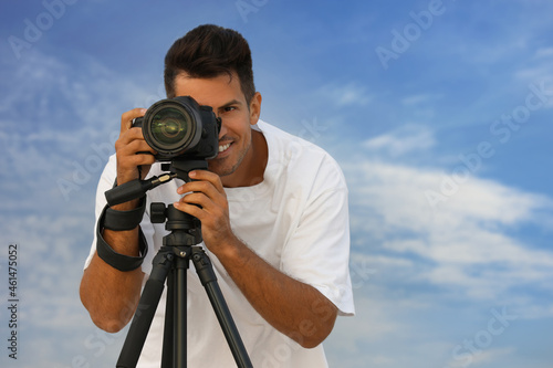 Photographer taking picture with professional camera outdoors