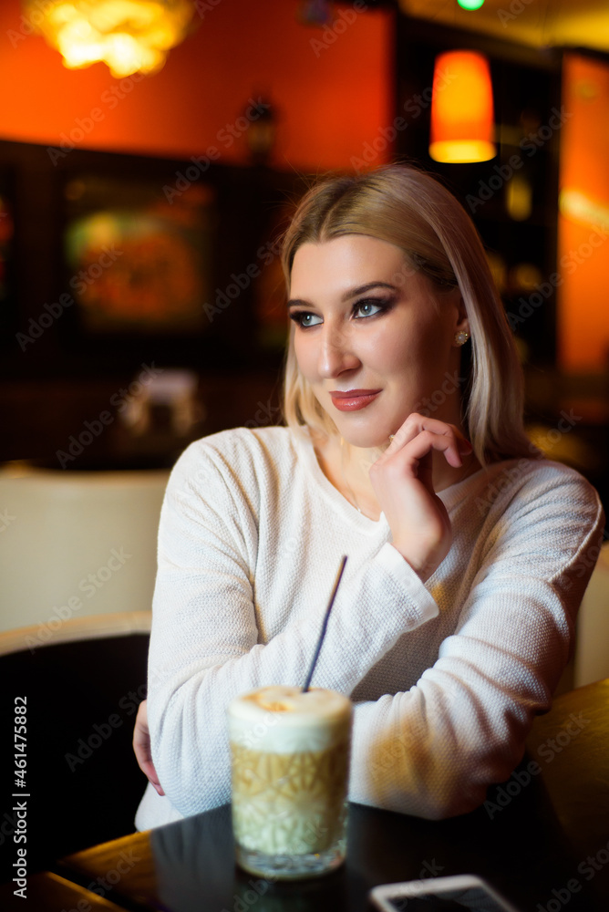Winter girl is drinking coffee. She enjoys her cappuccino or flat white. Winter girl is drinking coffee. She enjoys her cappuccino or flat white.