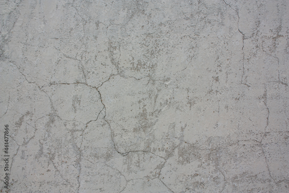 An old, gray wall with cracks and damage. Worn surface. Gray background with texture. An old, gray wall with cracks and damage. Worn surface. Gray background with texture.