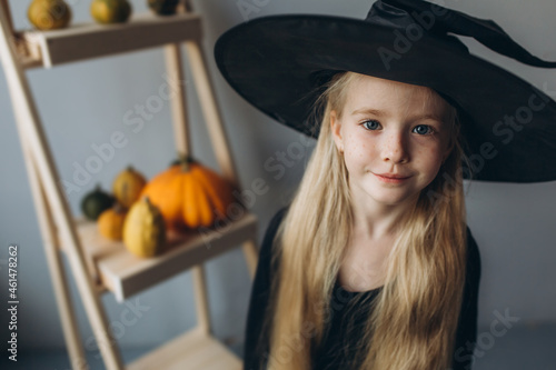 Halloween party, girl in witch costume with pumpkin 