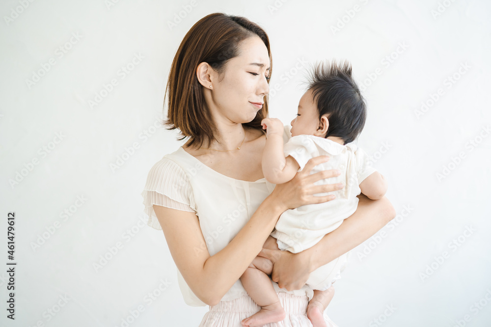 赤ちゃんを抱えて、疲れた表情をするお母さん 赤ちゃんを抱えて、疲れた表情をするお母さん