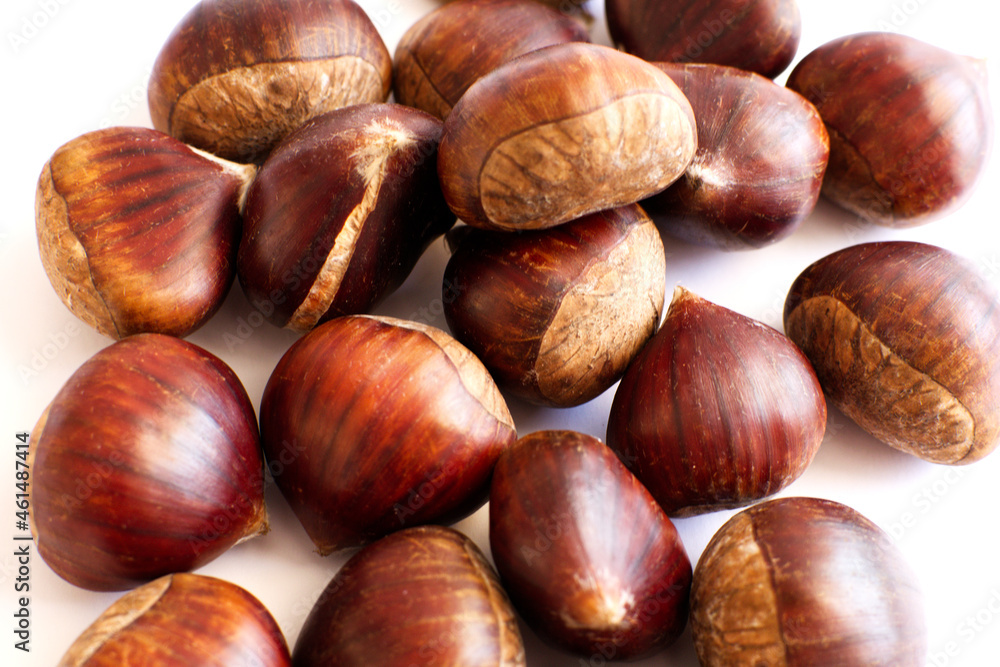 Pile of fresh sweet chestnuts isolated on white background. Chestnuts for roasting. Pile of fresh sweet chestnuts isolated on white background. Chestnuts for roasting.