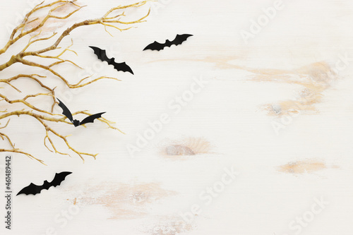 top view image of Halloween holoday. bare trees, bats over white wooden background photo