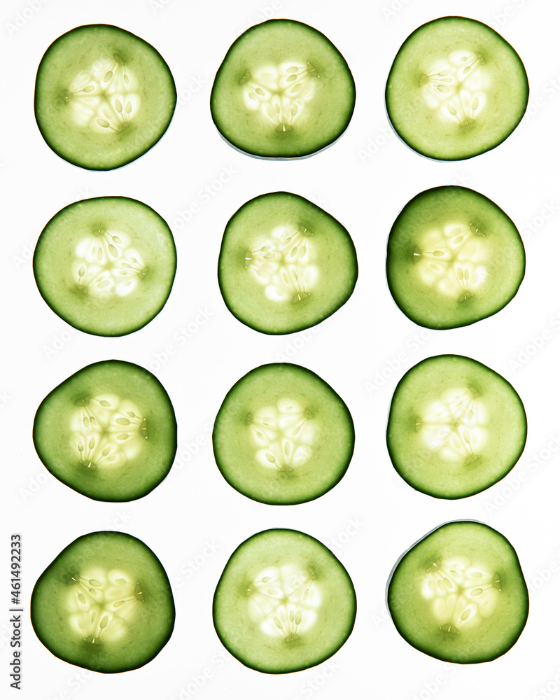Thin slices of cucumber shot on a backlit white surface Thin slices of cucumber shot on a backlit white surface