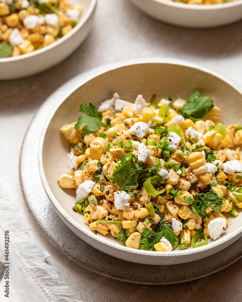 A neutral bowl filled with a vegan version of Mexican Street Corn Salad A neutral bowl filled with a vegan version of Mexican Street Corn Salad