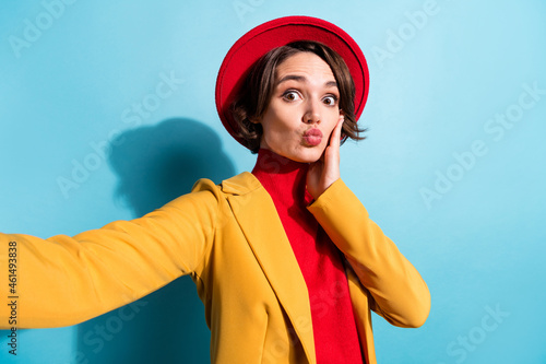 Photo of young girl happy positive smile shoot selfie blogger pouted lips send kiss isolated over blue color background