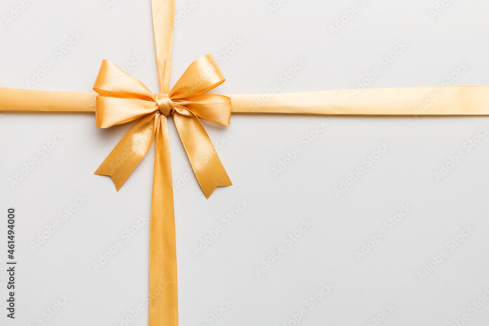 Top view of gold ribbon rolled and yellowbow isolated on colored background. Flat lay with copy space Top view of gold ribbon rolled and yellowbow isolated on colored background. Flat lay with copy space