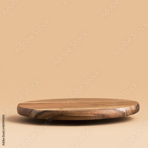 Round wooden floating podium for food  products or cosmetics against bright brown background.  