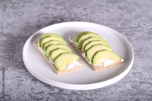 an appetizer of cottage cheese avocado and bread lies on a white plate