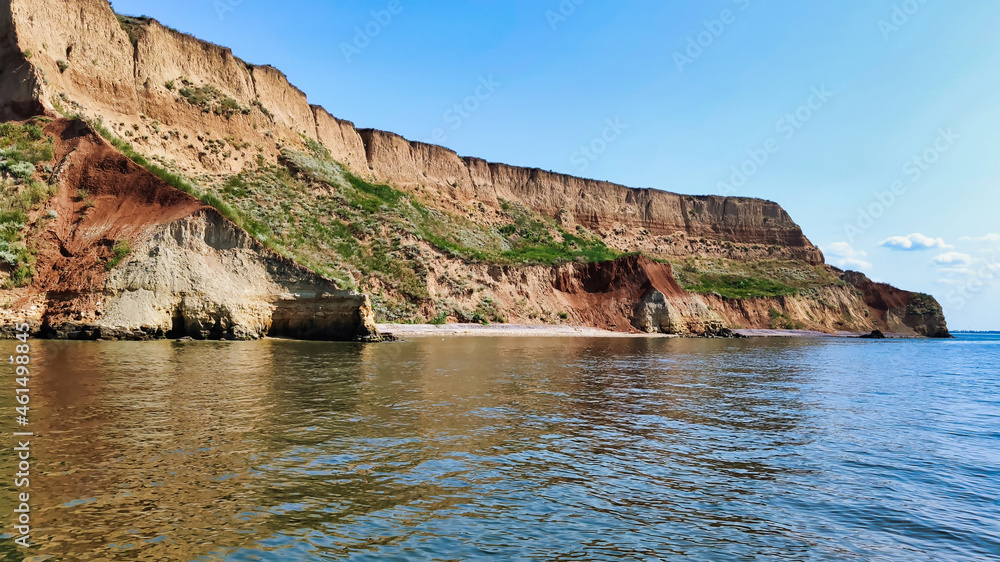 View of the Black Sea and colorful clay cliffs with green grass near Koblevo. Ukraine. Europe