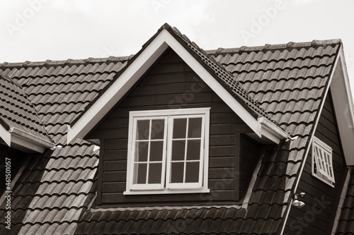 pitched roof dormer loft with white window and concrete tiles photo